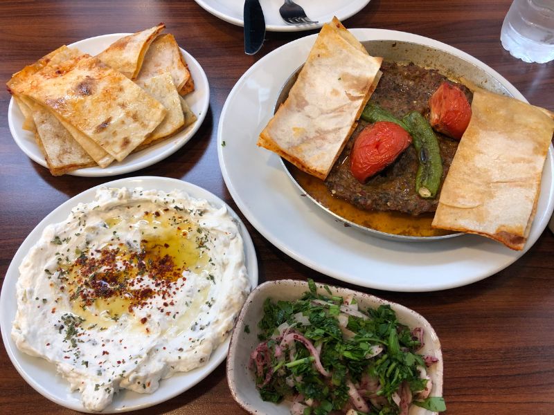 Spiced meat patty; red onion and parsley with sumac; yogurt egg-plant dip, flatbread