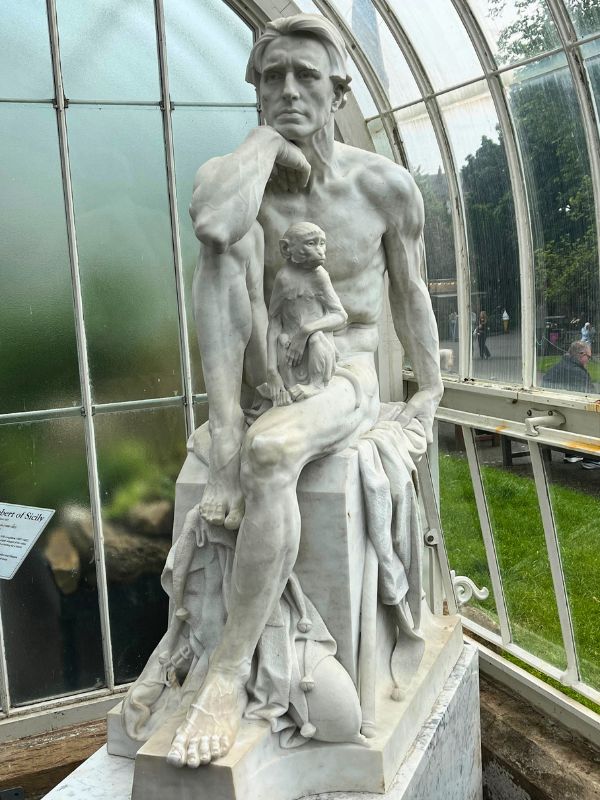 Statue in Botanical Gardens of King Robert of Sicily (from a Longfellow poem), "an arrogant king who was deposed by an angel, stripped of his robes, and forced to assume the role of a jester, with only a monkey for a friend."